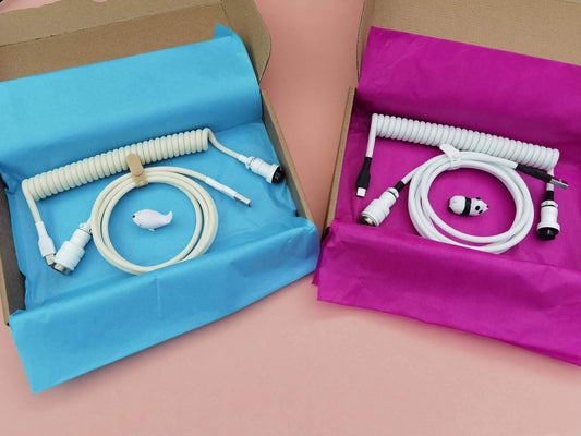 Packaged coiled cables by King Cables, ready to ship, one in white and one in cream color