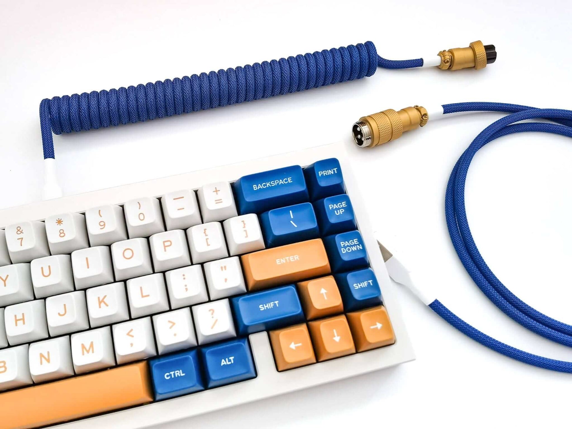 Blue coiled keyboard cable with gold Aviator connecotr on white keyboad with blue and white keycaps
