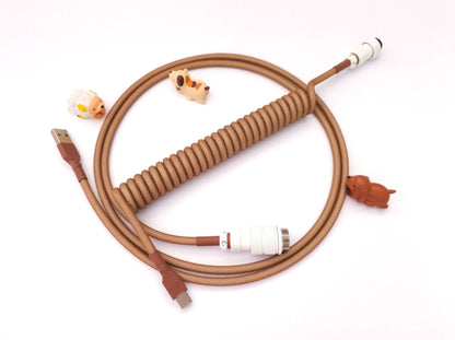 Chocolate keycaps cable in brown and white colors with white Gx16 connector a few cable bite protectors and USB C connection