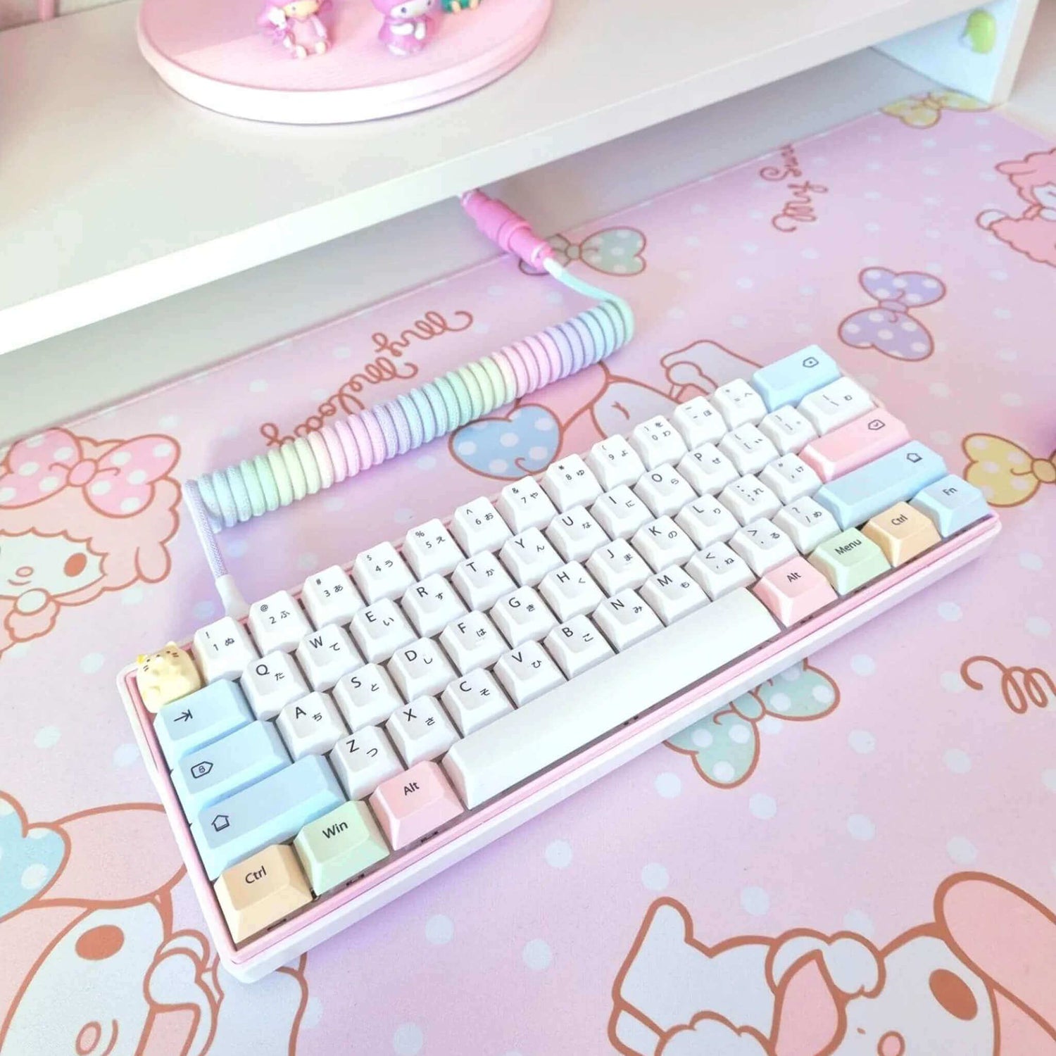 Pastel jelly Rainbow coiled cable on pastel colored custom keycaps and deskpad.