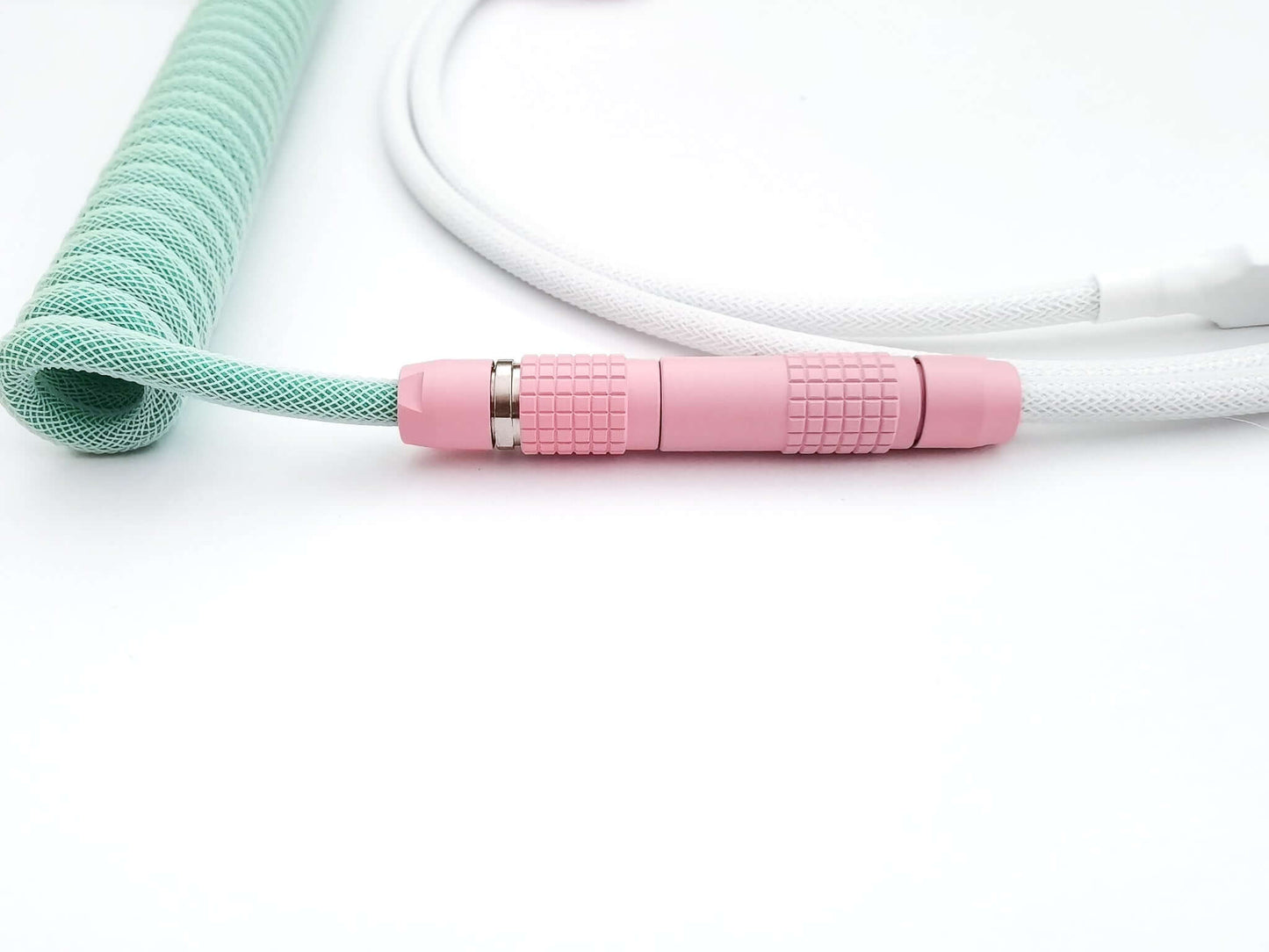 Pink Lemo connector on green coiled cable with white host cable
