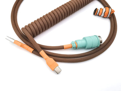 Brown coiled keyboard cable with orange heat shrink and teal Gx16 connector