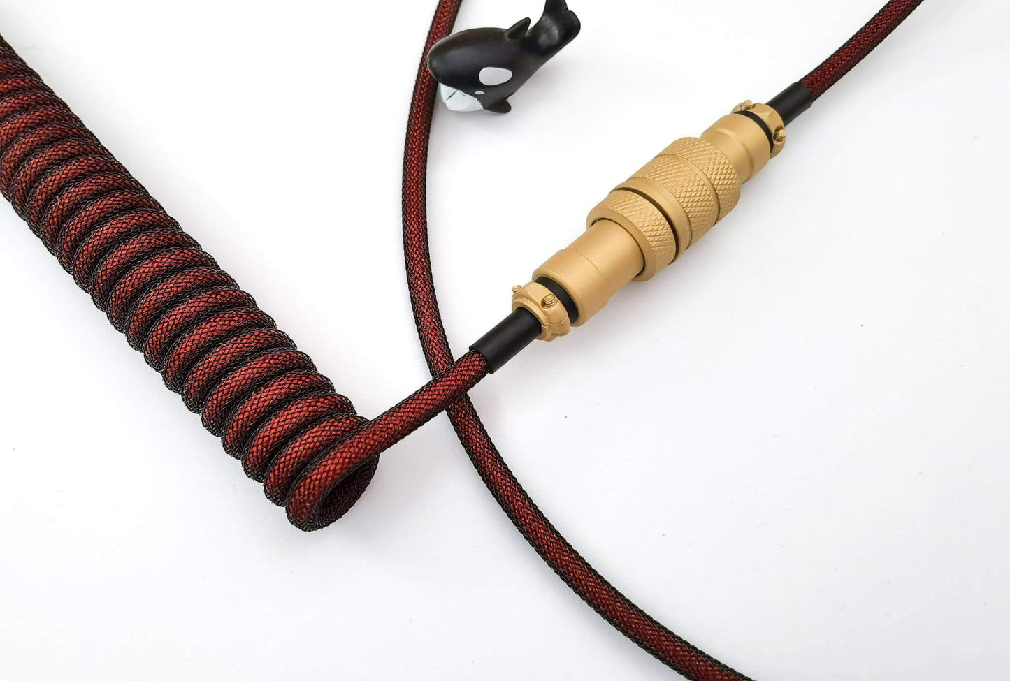 Golden Aviator connector on a dark red coil cable